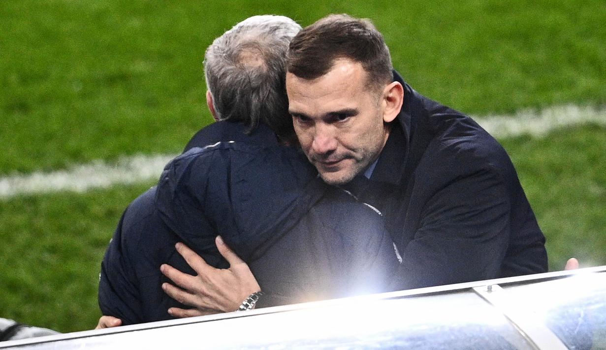 Pelatih Ukraina, Andriy Shevchenko, memeluk pelatih Prancis, Didier Deschamps, pada laga Kualifikasi Piala Dunia di Stadion Saint Denis, Paris, Kamis (25/3/2021). Kedua tim bermain imbang 1-1. (AFP/Anne-Christine Poujoulat)
