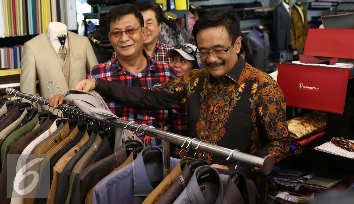 Calon Wakil Gubernur DKI Jakarta Djarot Saiful Hidayat membeli baju batik saat blusukan di kawasan Pasar Baru, Jakarta, Senin (14/11). Sebelumnya pada blusukan ini Djarot sempat mendapat penolakan dari sejumlah warga. (Liputan6.com/Gempur M. Surya)