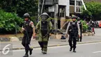 Petugas Gegana Polri meninggalkan pos polisi di perempatan Sarinah Jl MH Thamrin usai melakukan penyisiran, Jakarta, Kamis (14/1/2016). Pasca ledakan, aparat Gegana langsung melokalisir tempat kejadian perkara (TKP). (Liputan6.com/Helmi Fithriansyah)
