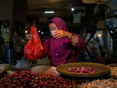 Pedagang melayani pembeli di Pasar Senen, Jakarta, Kamis (11/2/2021). Presiden Joko Widodo atau Jokowi memastikan vaksinasi COVID-19 di sektor pelayanan publik akan dimulai pekan depan. (Liputan6.com/Faizal Fanani)