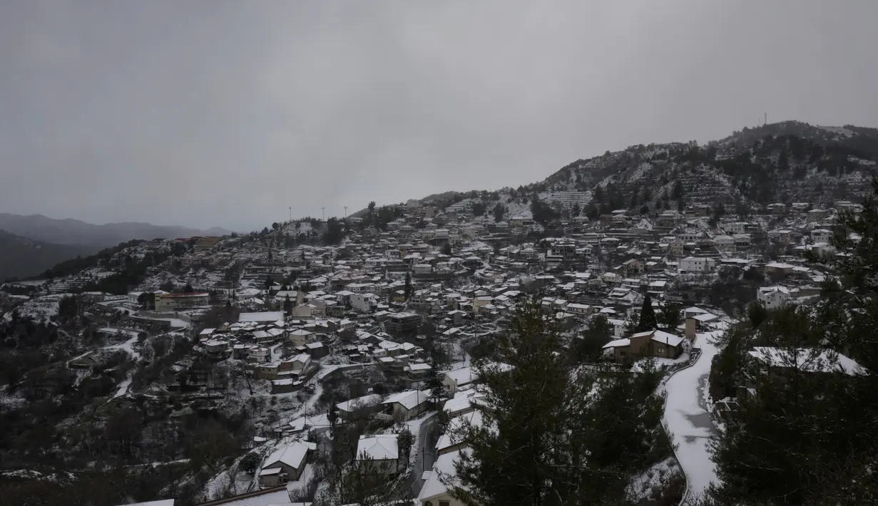 Salju menutupi rumah-rumah saat hujan salju di desa Kyperounta di gunung Troodos, pulau Mediterania tenggara Siprus, Rabu (19/1/2022). Siprus berada dalam cengkeraman badai pertengahan musim dingin yang membawa hujan lebat, suhu rendah, dan salju masuk pegunungan Troodos. (AP Photo/Petros Karadjias)