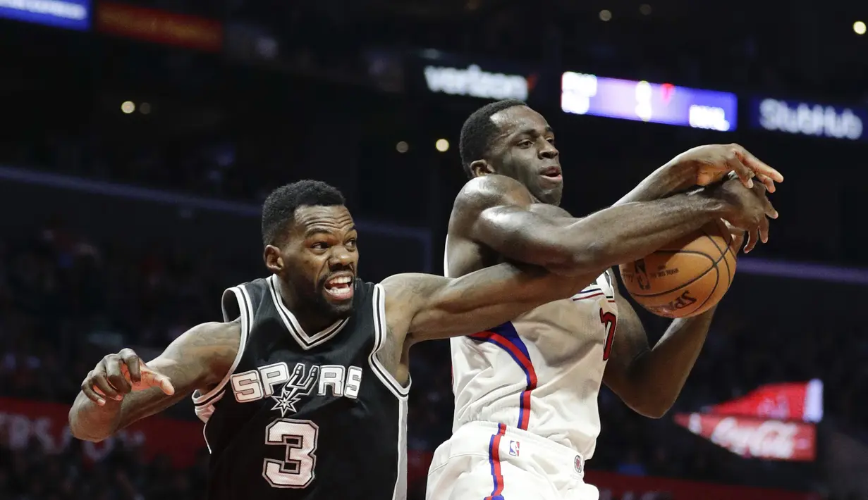 Pemain Los Angeles Clippers, Brandon Bass (kanan) berebut bola dengan pemain,  San Antonio Spurs, Dewayne Dedmon pada laga NBA basketball game di Staples Center, (22/12/2016). Clippers menang 106-101. (AP/Jae C. Hong)