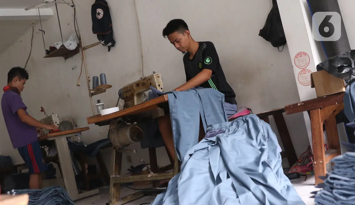Para pekerja menyelesaikan pembuatan seragam sekolah di usaha konveksi skala rumah tangga Kebayoran Lama, Jakarta, Kamis (9/7/2020). Pandemi virus corona COVID-19 berdampak pada sepinya pesanan pembuatan seragam sekolah. (Liputan6.com/Angga Yuniar)