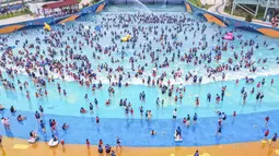 Suasana foto udara warga China bersantai di kolam renang Lianyungang, provinsi Jiangsu timur, China (4/7/2021). Di tengah pandemi Covid-19, warga China asyik menonton pertunjukan papan luncur saat mereka mendinginkan diri di kolam renang sambil bersantai. (AFP/STR)