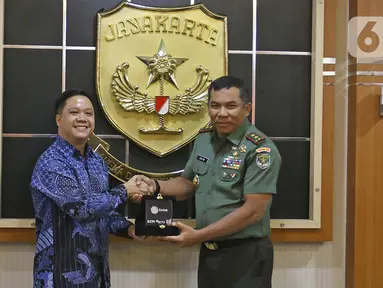 Director Programming SCTV, David Suwarto (kiri) memberikan plakat ke Pangdam Jaya Mayjen TNI Eko Margiyono seusai kunjungan di Makodam Jaya, Jakarta, Selasa (10/12/2019). Kunjungan ini untuk menjalin hubungan kedua pihak. (Liputan6.com/Herman Zakharia)