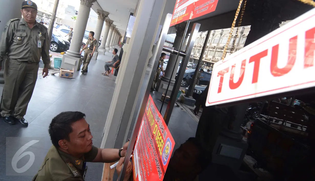 Petugas Satpol PP menyegel sebuah tempat Spa and Massage di Ruko De Mansion, Alam Sutera, Tangerang, Selasa (23/2). Sebanyak 6 tempat Spa and Message disegel Pemerintah Kota tangerang karena tidak mengantongi ijin operasi. (Liputan6.com/Faisal R Syam)