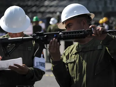 Tentara mencatat nomor seri dan model senjata otomatis selama penghancuran senjata api yang disita dari penjahat atau diserahkan oleh orang-orang, di Kamp Militer 1-A di Kota Meksiko, (1/8). (AFP Photo/Bernardo Montoya)