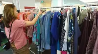 Seorang pengunjung acara #TukarBaju sedang memilih-milih pakaian. (Liputan6.com/Dinny Mutiah)
