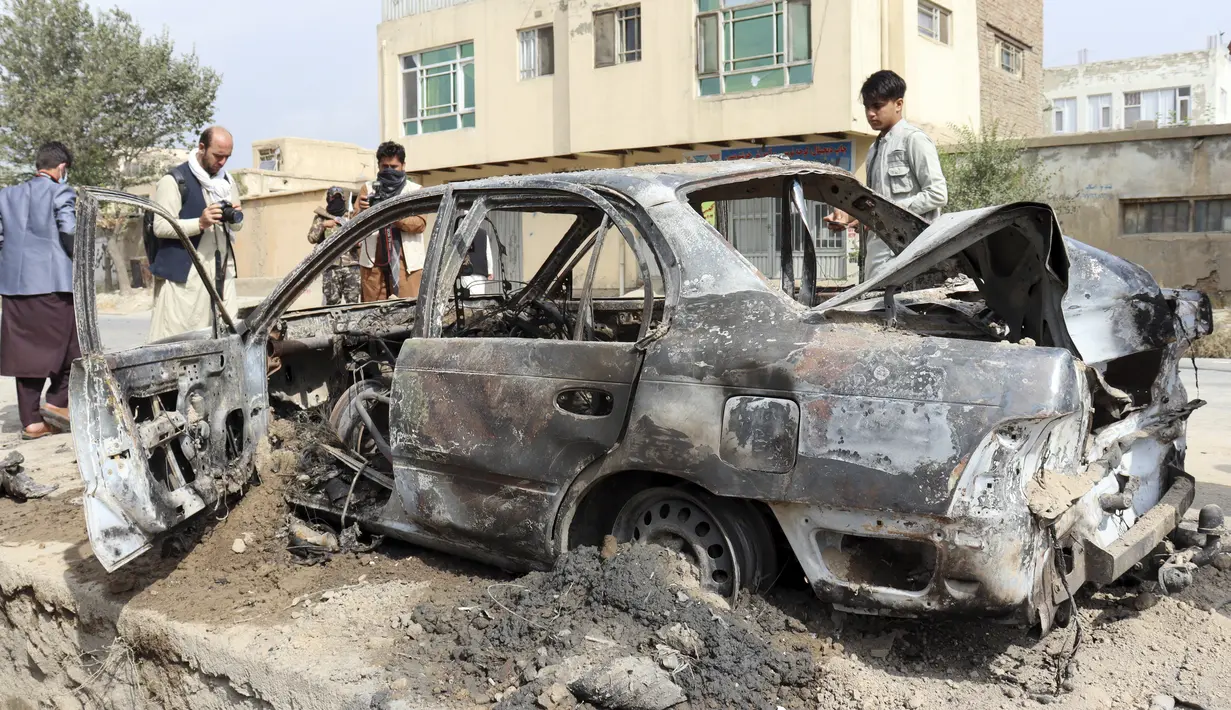 Wartawan mengambil foto kendaraan yang rusak akibat serangan roket di Kabul, Afghanistan, Senin (30/8/2021). Tidak diketahui jelas siapa yang meluncurkan roket tersebut. (AP Photo/Khwaja Tawfiq Sediqi)