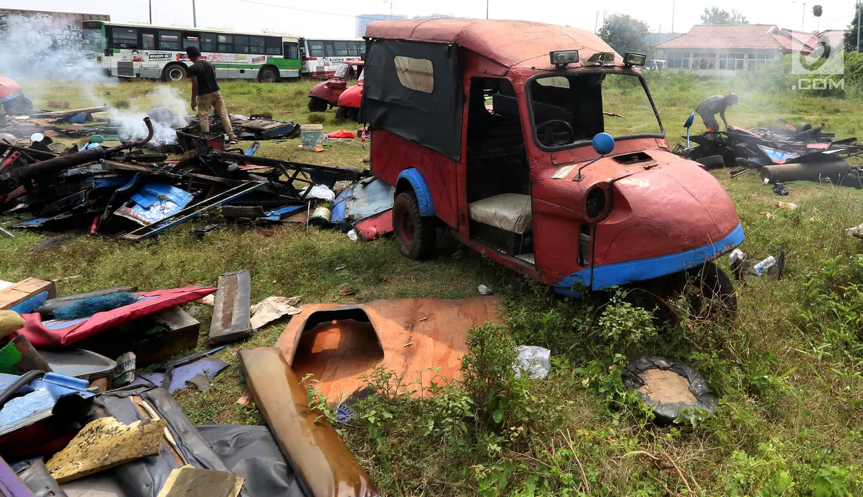 Pekerja memusnahkan bemo hasil razia di sejumlah wilayah di Jakarta, di pool Rawa Buaya, Cengkareng, Jakarta Barat, Selasa (1/8). Pemusnahan dilakukan, dikarenakan sejak 6 Juni 2017, Dishub DKI melarang bemo beroperasi. (Liputan6.com/Johan Tallo)