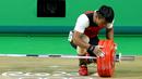 Deni melihat barbel yang gagal diangkatnya saat berlaga di Olimpiade 2016, Brasil, Rabu (10/8). Deni yang memiliki berat tubuh 69.38kg, tidak bermain di kelasnya, dan lawan-lawannya memiliki tubuh jauh lebih berat. (REUTERS/Athit Perawongmetha)