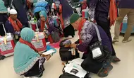 Sejumlah jemaah haji terpaksa membongkar lagi kopernya untuk mengeluarkan barang-barang yang dilarang dibawa dalam penerbangan pulang ke Tanah Air. Pembongkaran koper ini dilakukan di Terminal Haji Bandara King Abdul Aziz, Jeddah, Arab Saudi. (Liputan6.com/Dinny Mutiah)