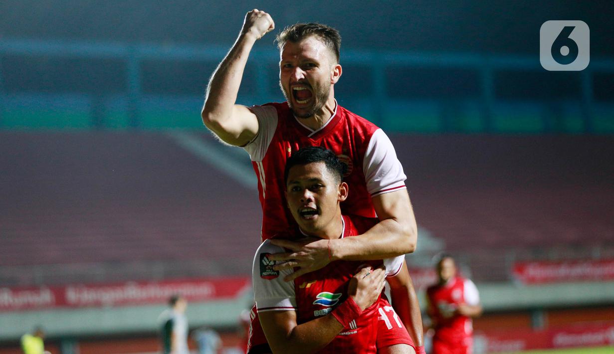 Pemain Persija Jakarta, Taufik Hidayat (bawah) melakukan selebrasi bersama Marco Motta usai mencetak gol ke gawang melawan Persib Bandung pada laga final Piala Menpora 2021 di Stadion Maguwoharjo, Sleman, Kamis (22/4/2021). Persija menang dengan skor 2-0. (Bola.com/M Iqbal Ichsan)