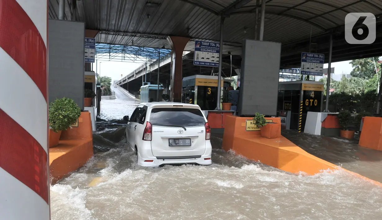 Mobil nekat menerobos banjir menuju Gerbang Tol Cempaka Putih, Jakarta, Minggu (23/2/2020). Banjir yang melanda kawasan tersebut menyebabkan Gerbang Tol Cempaka Putih tidak dioperasikan akibat terendam hingga ketinggian mencapai sepinggang orang dewasa. (merdeka.com/Iqbal S. Nugroho)