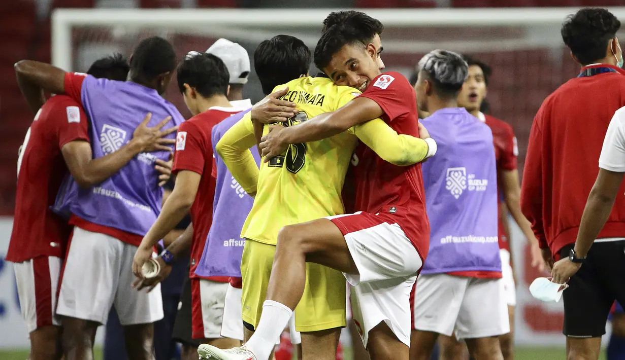 Kiper Timnas Indonesia, Nadeo Argawinata yang mampu mengagalkan tendangan penalti pemain Singapura mendapat pelukan hangat dari rekannya Rizky Ridho di akhir laga. (AP/Suhaimi Abdullah)