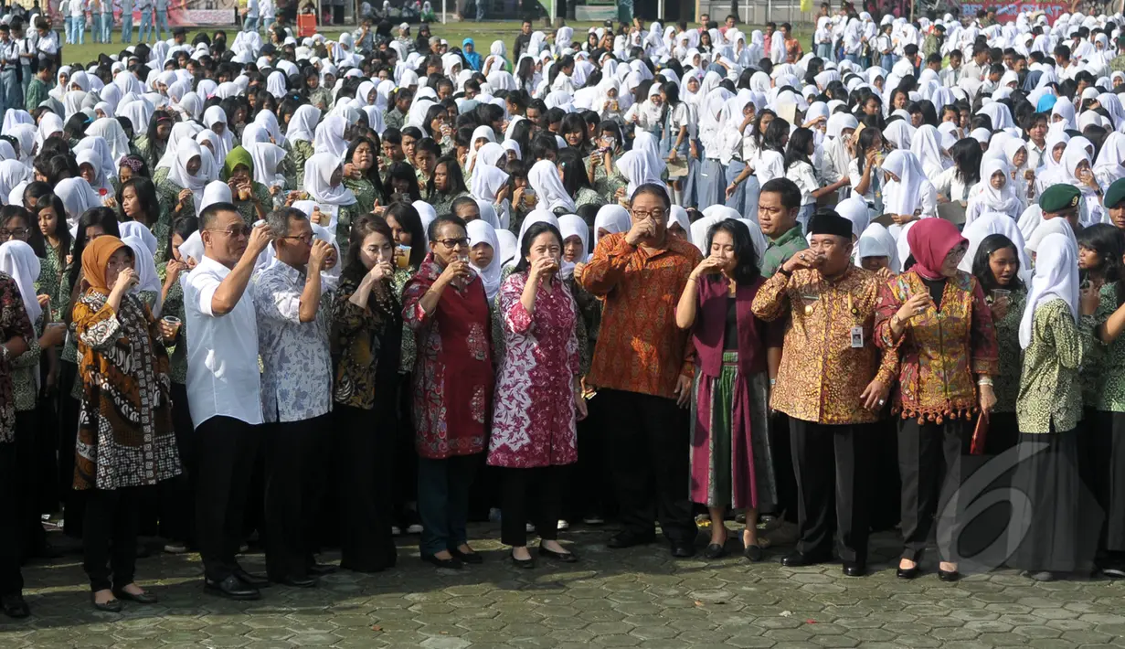 Menteri Koordinasi Bidang Pembangunan Manusia dan Kebudayaan, Puan Maharani (tengah) bersama ribuan pelajar minum jamu bersama di Alun-alun Satya Negara Sukoharjo, Jawa Tengah, Rabu (1/4/2015). (Liputan6.com/Johan Tallo)