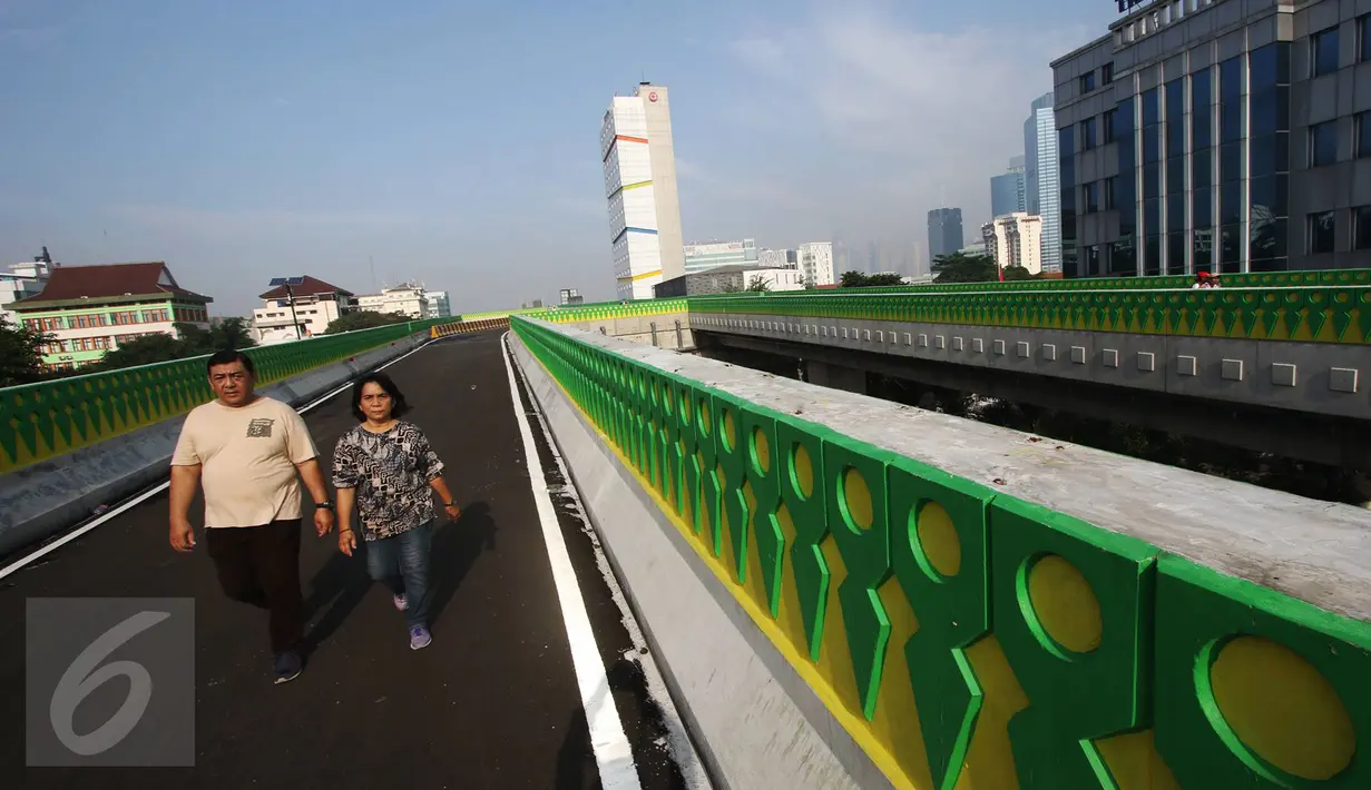 Warga berjalan santai di sepanjang jalan layang Transjakarta rute Cileduk-Tendean di Jakarta, Minggu (26/2). Belum beroperasinya jalan sepanjang 9,3 km tersebut dimanfaatkan warga untuk mengisi kegiatan saat Minggu pagi. (Liputan6.com/Immanuel Antonius)