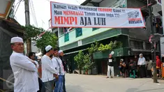 Sejumlah warga berdiri di bawah spanduk penolakan penggusuran Kampung Luar Batang, Penjaringan, Jakarta, Rabu (20/4). Mereka menolak pembongkaran tahap dua yang akan dilakukan Pemprov DKI pada Mei nanti. (Liputan6.com/Yoppy Renato)