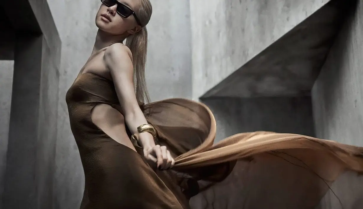 Warna camel brown dari gaunnya berpadu sempurna dengan rambut pirang Rose BLACKPINK, sehingga satu-satunya aksesori yang dibutuhkan hanya kacamata hitam metal cuff yang simpel. [Foto: Instagram/vanityfair]