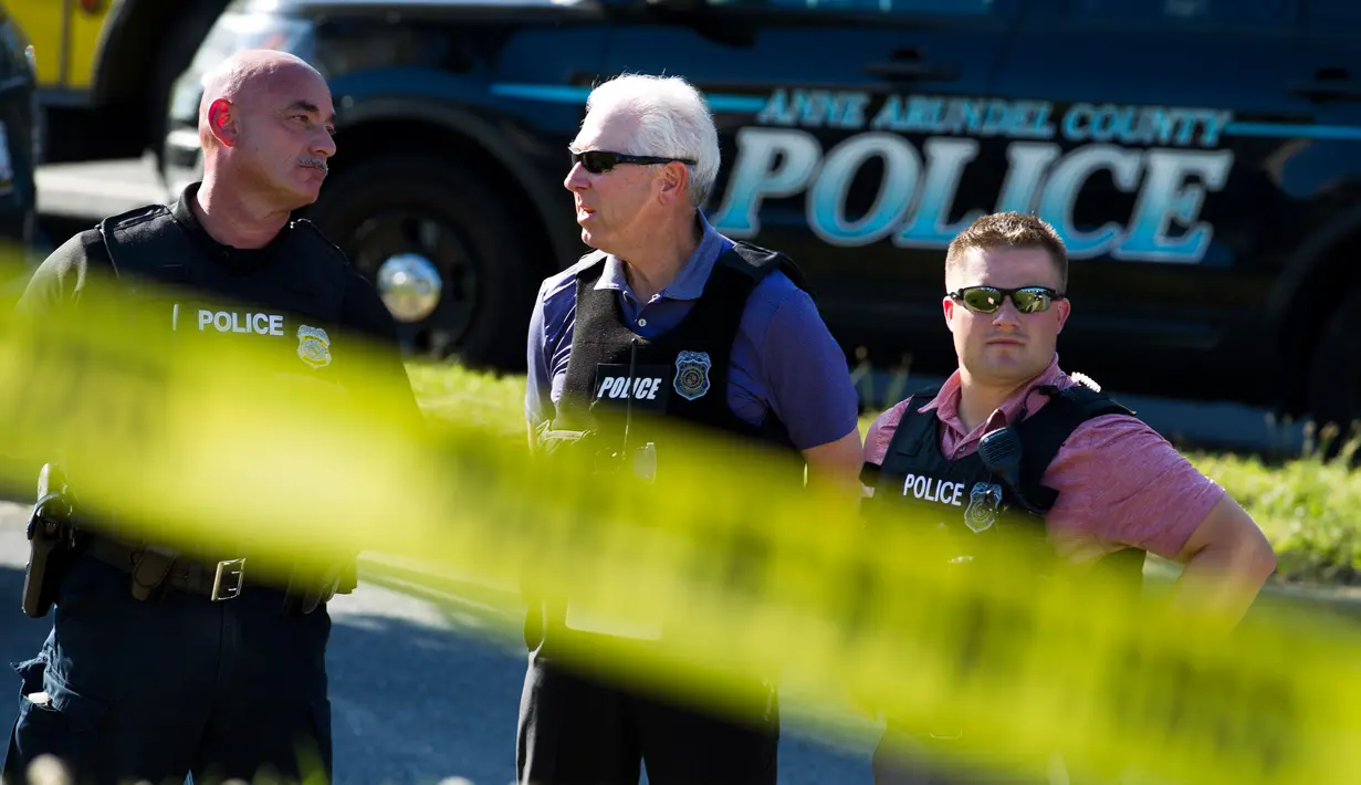 Aparat kepolisian mengamankan lokasi penembakan brutal di kantor surat kabar lokal Capital Gazette di Annapolis, AS, Kamis (28/6). Kepolisian mengatakan penembakan di kantor surat kabar Capital Gazette bukan bentuk tindakan terorisme (AP/Jose Luis Magana)