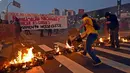 Dalam aksinya, pekerja kereta bawah tanah dan anggota MTST (Gerakan Pekerja Tunawisma) Brasil memblokade jalan dengan membakar beberapa atribut, Sao Polo, (9/6/2014). (AFP PHOTO/NELSON Almeida)