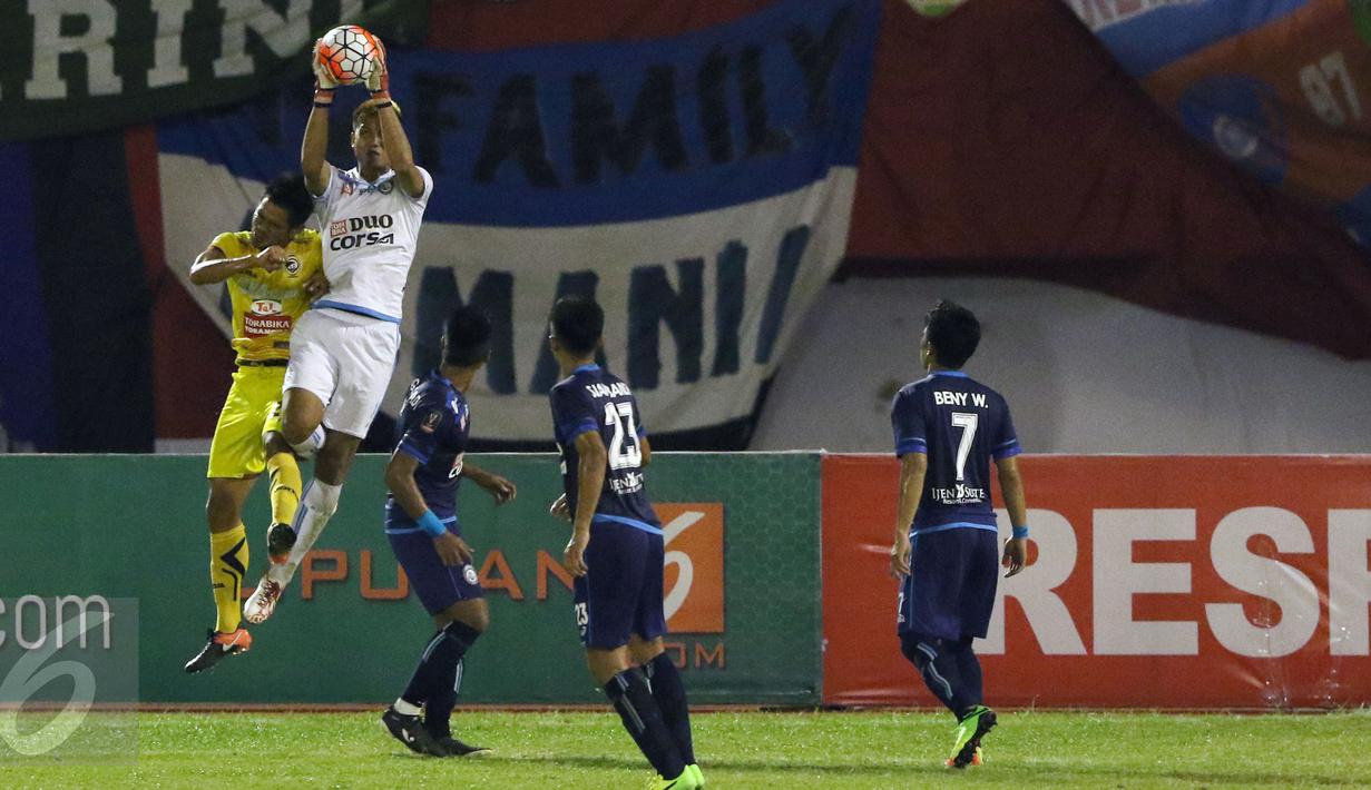 Kiper Arema FC, Kurnia Meiga (kedua kiri) menangkap bola saat laga 8 besar Piala Presiden 2017 melawan Sriwijaya FC di Stadion Manahan, Solo, Minggu (26/2). Arema melaju ke semifinal setelah unggul 1-0. (Liputan6.com/Helmi Fithriansyah) 