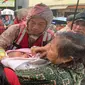 Seorang Petugas Kepolisian Saat Mengevakuasi Seorang Bayi yang Terjebak Banjir di Cipinang Melayu, Jakarta Timur, Rabu (1/1/2020). (Foto: Merdeka.com)