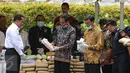 Presiden Jokowi mengamati barang bukti narkoba hasil rampasan BNN di Monas, Jakarta, Selasa (6/12). Pemusnahan terdiri dari 445 kg sabu, 190 ribu butir ekstasi, 422 kg ganja kering dan 323 ribu butir happy five. (Liputan6.com/Faizal Fanani)