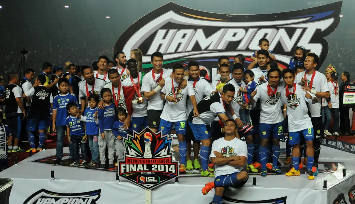 Firman Utina (duduk) bergaya di podium juara Indonesia Super League 2014 di Stadion Gelora Sriwijaya, Palembang, (7/11/2014). (Liputan6.com/Helmi Fithriansyah)