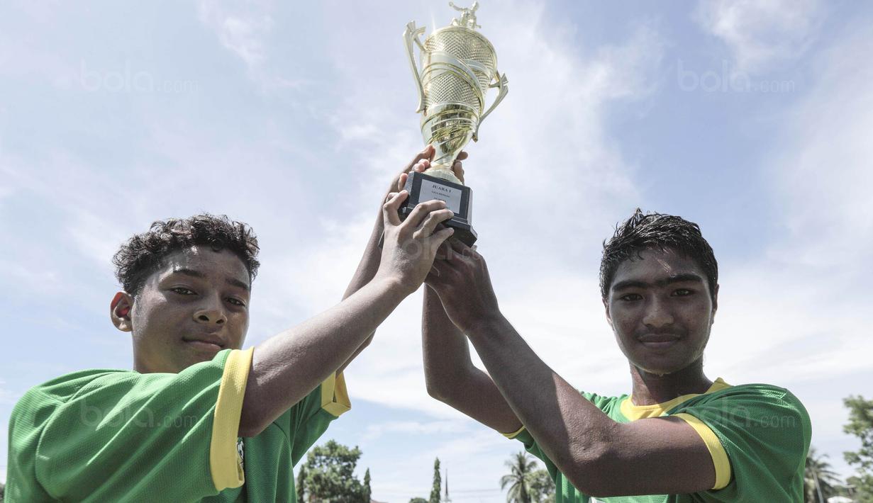 Para pemain SSB Maehanu merayakan gelar juara Liga Remaja UC News setelah mengalahkan SSB Tulehu Putra pada laga final di Lapangan Masariku Yonif 733, Ambon, Kamis (30/11/2017). SSB Maehanu menang 1-0 atas SSB Tulehu putra. (Bola.com/Peksi Cahyo)