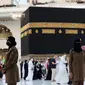 Para polisi wanita Saudi berjaga-jaga saat jemaah mengelilingi Ka'bah pada rangkaian ibadah haji di Masjidil Haram, Makkah, Selasa (20/7/2021). Kini, para personel perempuan bergabung dengan rekan-rekan pria mereka dalam menjaga kota suci selama musim haji. (Fayez Nureldine / AFP)