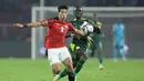 Gelandang Mesir Emam Ashour (kiri) berebut bola dengan pemain depan Senegal Sadio Mane pada pertandingan final Piala Afrika 2021 di Paul Biya Stadium, Kamerun, Senin (7/2/2022) dini hari WIB. Sadio Mane membawa Senegal mengalahkan Mesir lewat adu penalti dengan skor 4-2. (Kenzo TRIBOUILLARD / AFP)