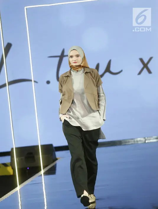 Model berjalan di atas catwalk mengenakan busana L.tru X Fenita Arie dalam ajang Jakarta Modest  Fashion Week, di Gandaria City, Jakarta, Jumat, (27/7). (Kapanlagi.com/Agus Apriyanto)