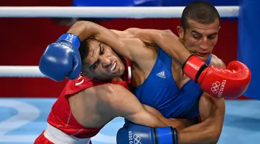 Petinju Iran Daniyal Shahbakhsh (merah) melawan petinju Maroko Mohamed Hamout dalam pertandingan tinju putra (52-57kg) pada Olimpiade Tokyo 2020 di Kokugikan Arena di Tokyo pada 24 Juli 2021. (AFP/ Luis Robayo)