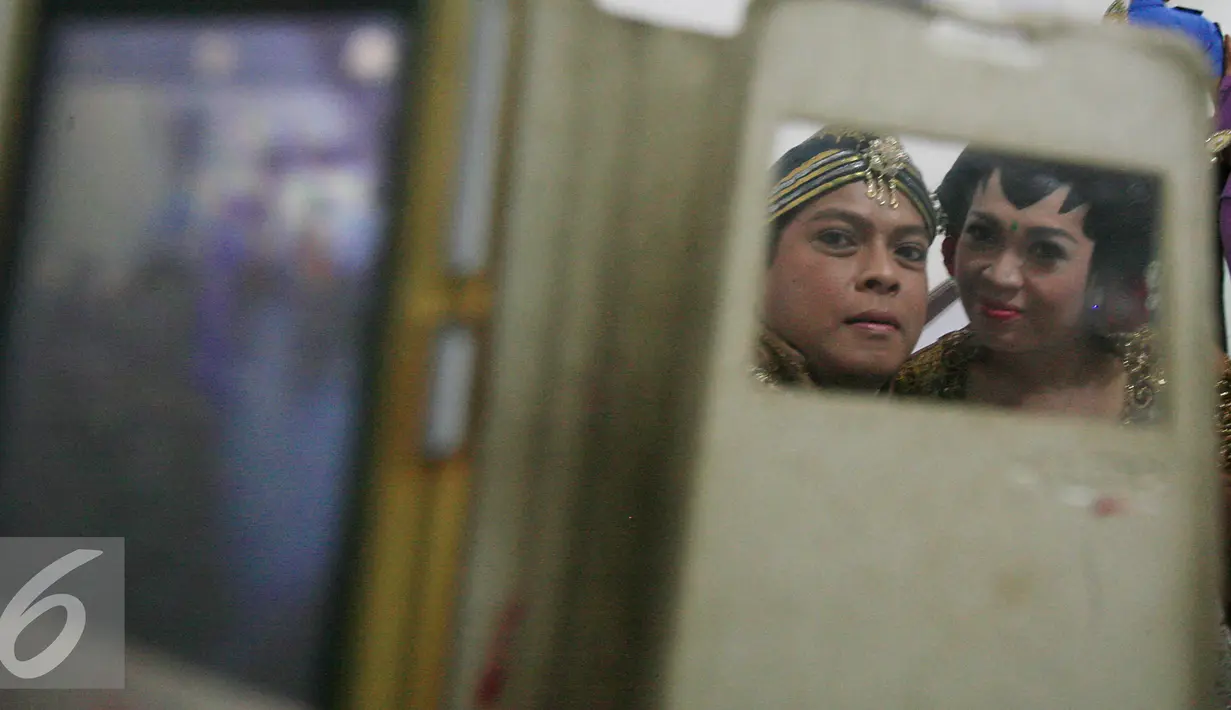 Calon pasangan mempelai berselfie sebelum mengikuti peragaan busana pengantin di Pasar Beringharjo Yogyakarta , (3/2). Busana akan di pakai saat nikah massal yang akan di gelar 4 April 2016. (Liputan6.com/Boy Harjanto)