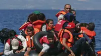 Sejumlah pengungsi Suriah berada di perahu karet yang bocor sekitar 100 m sebelum mencapai pulau Lesbon, Yunani, Minggu (13/09/2015). Total 432.761 pengungsi melakukan perjalanan berbahaya menuju Eropa. (REUTERS/Alkis Konstantinidis)