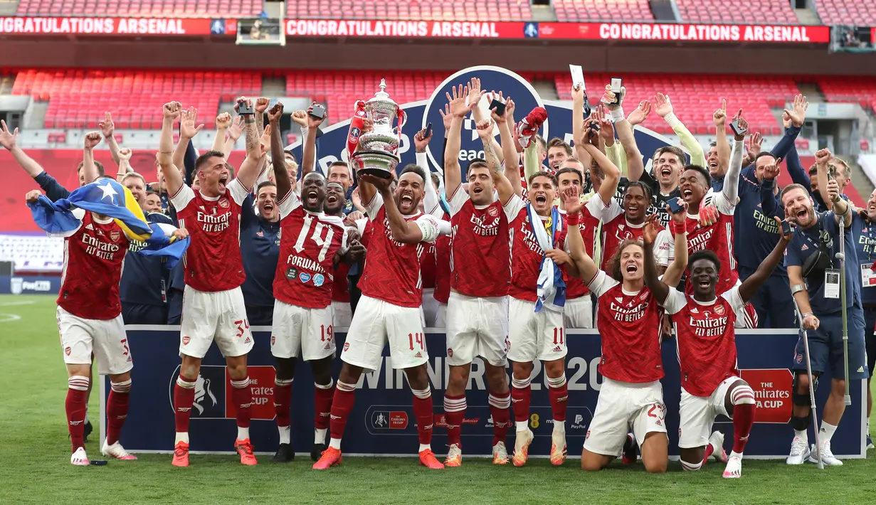 Para pemain Arsenal mengangkat trofi Piala FA setelah mengalahkan Chelsea pada pertandingan final Piala FA di stadion Wembley, London, Minggu (2/8/2020) dini hari. Arsenal juara Piala FA setelah menang dengan skor 2-1. (Catherine Ivill/Pool via AP)