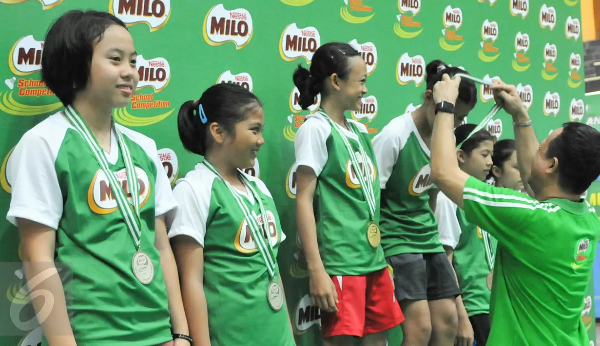 Legenda Bulutangkis Indonesia, Rexy Mainaky menyerahkan hadiah kepada juara ganda putri MILO School Competition 2015, Jakarta, Sabtu (28/11/2015). (Liputan6.com/Yoppy Renato)
