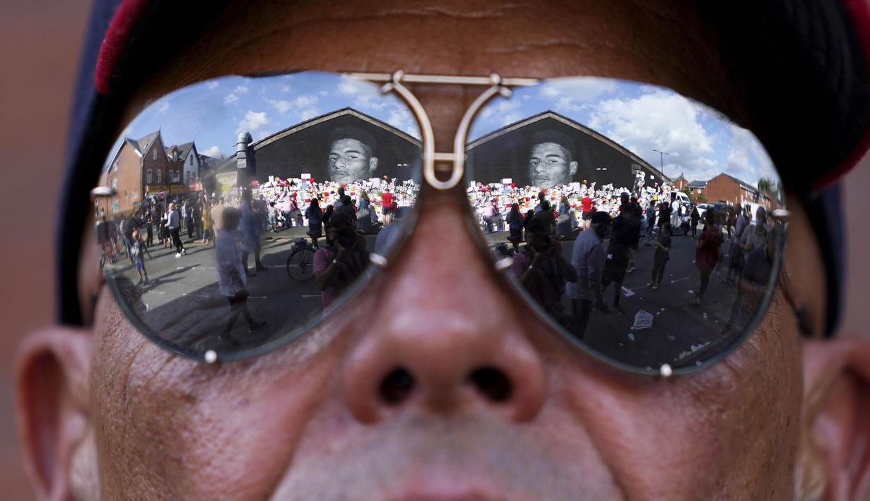 Ratusan orang berkumpul untuk menggelar aksi anti Rasisme di depan mural wajah pemain Timnas Inggris, Marcus Rashford di Withingston, Manchester. (Foto:AP/Jon Super)