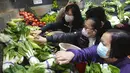 Pelanggan mengenakan masker, membeli sayuran segar di toko pasar basah di Hong Kong, Rabu, 9 Februari 2022. Hong Kong memberlakukan langkah-langkah jarak sosial yang paling ketat untuk mempertahankan kebijakan nol COVID-19 di tengah lonjakan kasus yang dipicu Varian Omicron. (AP Photo/Vincent Yu)