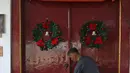 Pekerja menghias pintu Gereja Tugu dengan ornamen Natal, Jakarta, Senin (23/12/2019). Sejumlah perlengkapan ibadah telah disiapkan untuk menyambut Natal. (Liputan6.com/Herman Zakharia)
