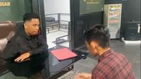Polisi saat menginterogasi&nbsp;IPT (32), oknum guru sekaligus wali kelas 5 SD Inpres Mangga Tiga, Kecamatan Biringkanaya, Kota Makassar, Sulawesi Selatan, yang diduga melakukan pelecehan seksual kepada siswanya. (Liputan6.com/ Fauzan)