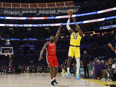 Pebasket Los Angeles Lakers, LeBron James melakukan lemparan three poin dibayangi pebasket New Orleans Pelicans, Zion Williamson untuk mencetak 50.002 poin dalam sejarah NBA di Crypto Arena, Los Angeles, Rabu (05/03/2025) pagi WIB. (AFP/Getty Images/Ronald Martinez)