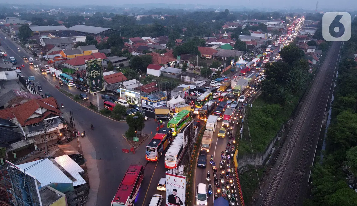 <p>Foto udara memperlihatkan kondisi lalu lintas di Simpang Jomin Pantura, Cikampek, Jawa Barat, Jumat (29/4/2022). Memasuki H-3 Idul Fitri, jalur mudik didominasi oleh kendaraan roda dua, truck dan mobil. (merdeka.com/Imam Buhori)</p>