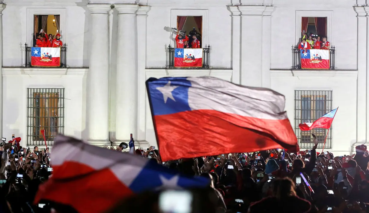 Setelah diarak menggunakan bus terbuka dari Stadion Nasional, pemain Cile merayakan kegembiraan juara Copa America 2015 bersama Presiden Cile, Michelle Bachelet. (REUTERS/Carlos Garcia Rawlins)