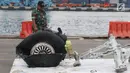 Petugas melihat-lihat bagian roda pesawat Lion Air PK-LQP JT 610 di Pelabuhan JICT 2, Jakarta, Senin (5/11). Bagian tersebut dipindah untuk dilakukan identifikasi dan pengecekan lebih lanjut oleh KNKT. (Liputan6.com/Helmi Fithriansyah)