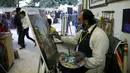 Seorang seniman melukis di kiosnya saat Festival Lok Mela di Islamabad, ibu kota Pakistan, pada 8 November 2020. Festival tersebut menyediakan panggung bagi para perajin untuk memamerkan karya seni mereka dan para seniman rakyat untuk menggelar pertunjukan mereka. (Xinhua/Ahmad Kamal)