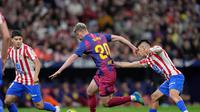 Pemain Barcelona, Dani Olmo (tengah), melindungi bola dari pemain Atletico Madrid, Thiago Almada dalam pertandingan Liga Spanyol di Madrid, Spanyol, Minggu (5/4/2026) dini hari WIB. (AP Photo/Bernat Armangue)