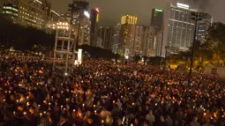 Ribuan warga  Hong Kong menyalakan lilin memperingati peristiwa Tiananmen di Hong Kong's Victoria Park, (4/6). Mereka mengenang tindakan brutal militer Tiongkok saat membubarkan demo mahasiswa di Lapangan Tiananmen. (AP Photo/Kin Cheung)