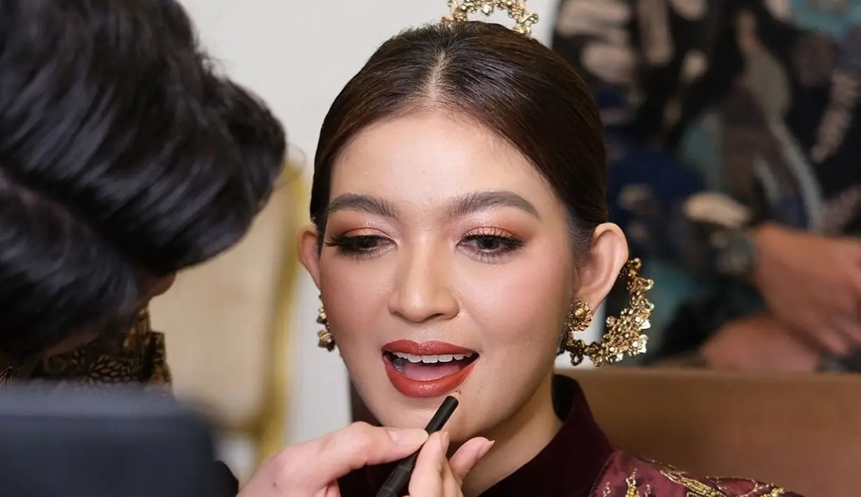 Pulasan makeup bold yang berfokus pada riasan mata yang tajam dan lipstik merah merona hasil tangan dingin makeup artist @rama_jee, buat penampilan istri Gibran Rakabuming Raka itu semakin memesona. [@rama_jee].